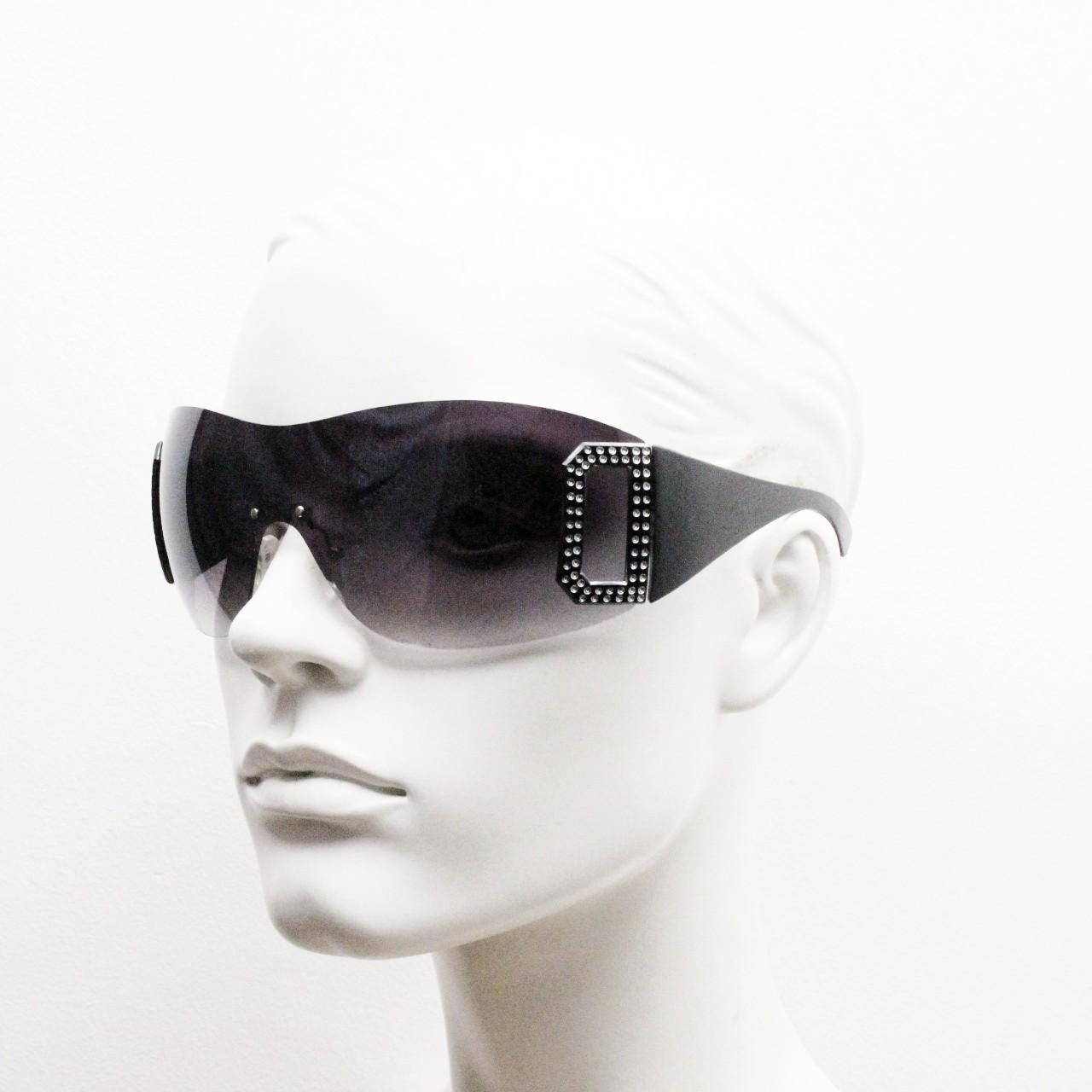Y2K vintage visor sunglasses. 2000's black wraparound mono lens shield design with big diamante effect crest. 00s uber fashion mini mask NOS