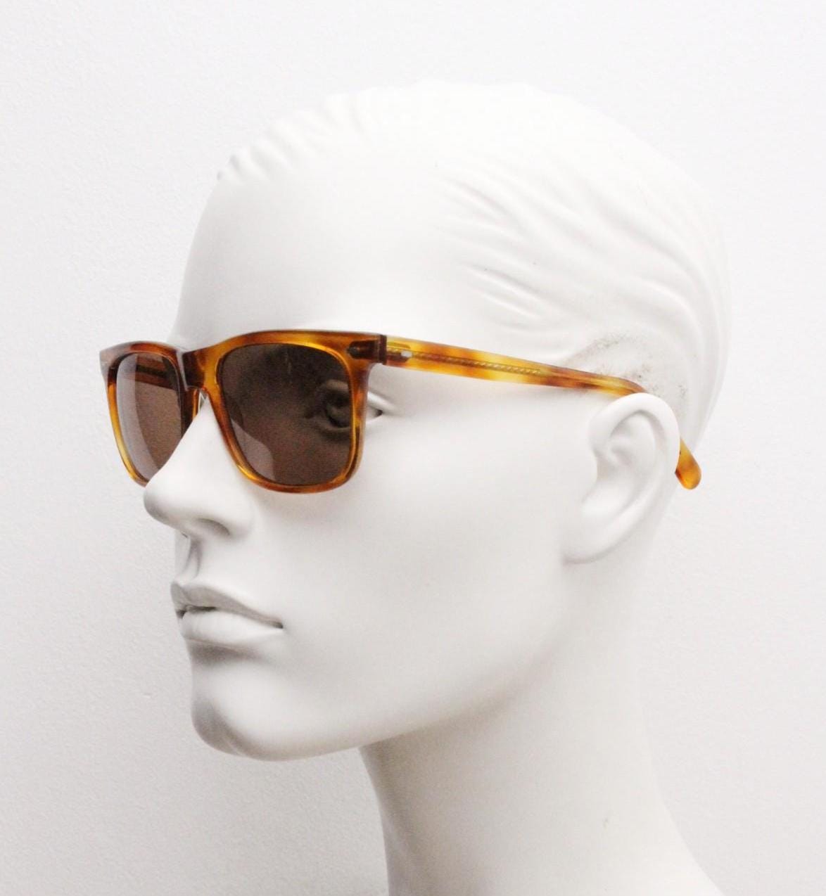 Uomo vintage 90s wayfarer design sunglasses made in Italy. All time classic format in mottled amber frame with contrasting brown lenses. NOS