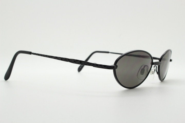 90s vintage oval sunglasses. Minimal plain matt black metal frame with unusual indented arm patterns. Unused NOS