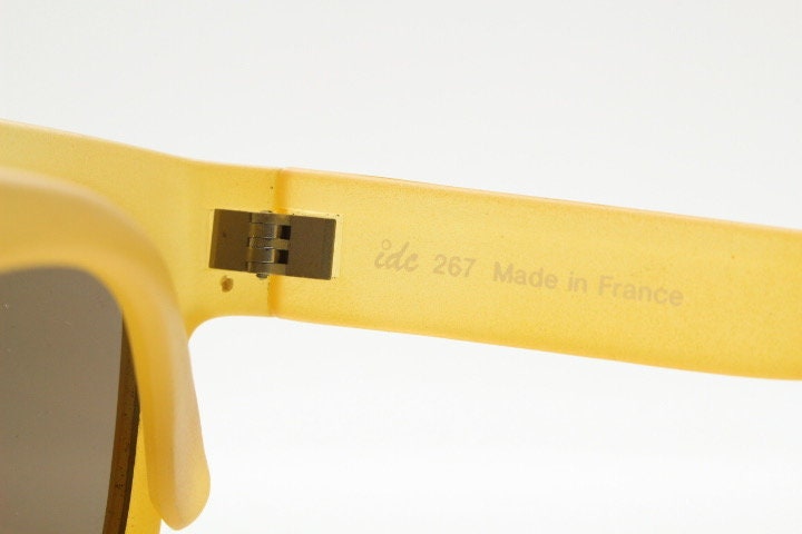 IDC lunettes modified wayfarer design sunglasses made in France. Transparent frosted yellow acetate chunky frame with contrasting lenses