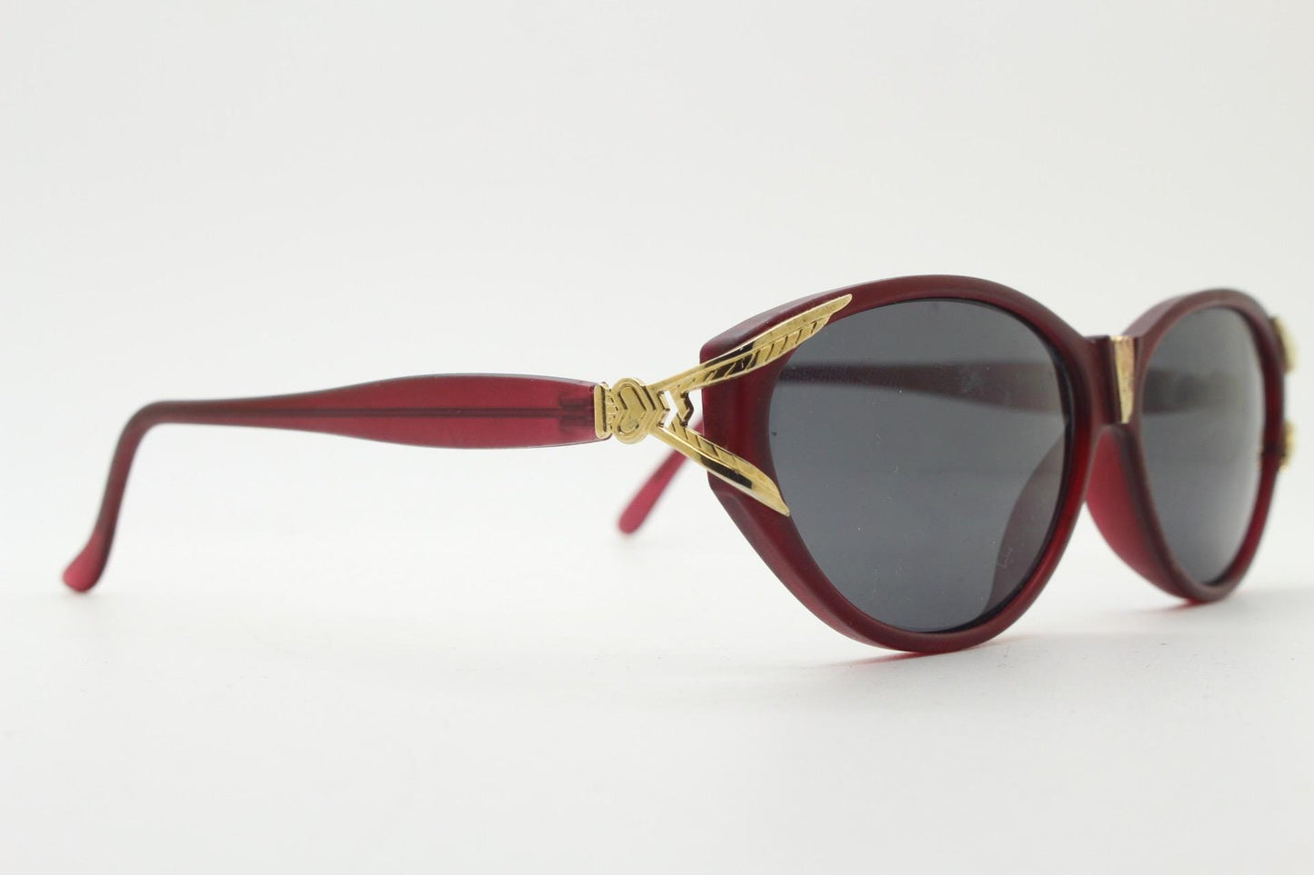 80s vintage Revlon cat eye sunglasses. Women's dark pink transparent frosted frame with golden Y fork ornate temples. 90s cateye. NOS
