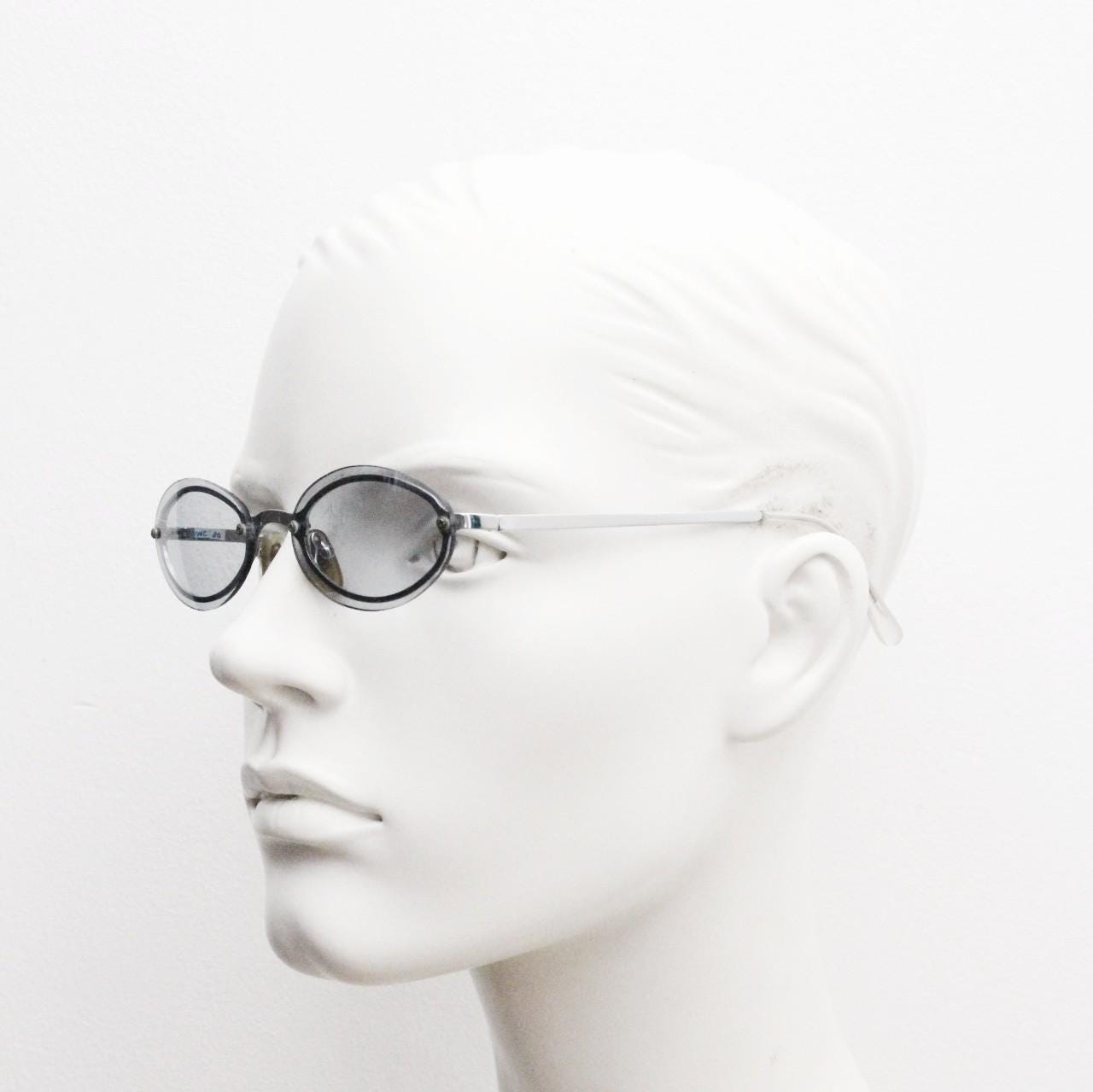 90s vintage small oval sunglasses. Minimal silver chrome metal frame with overlapping light tone grey lenses. Micro. Steampunk