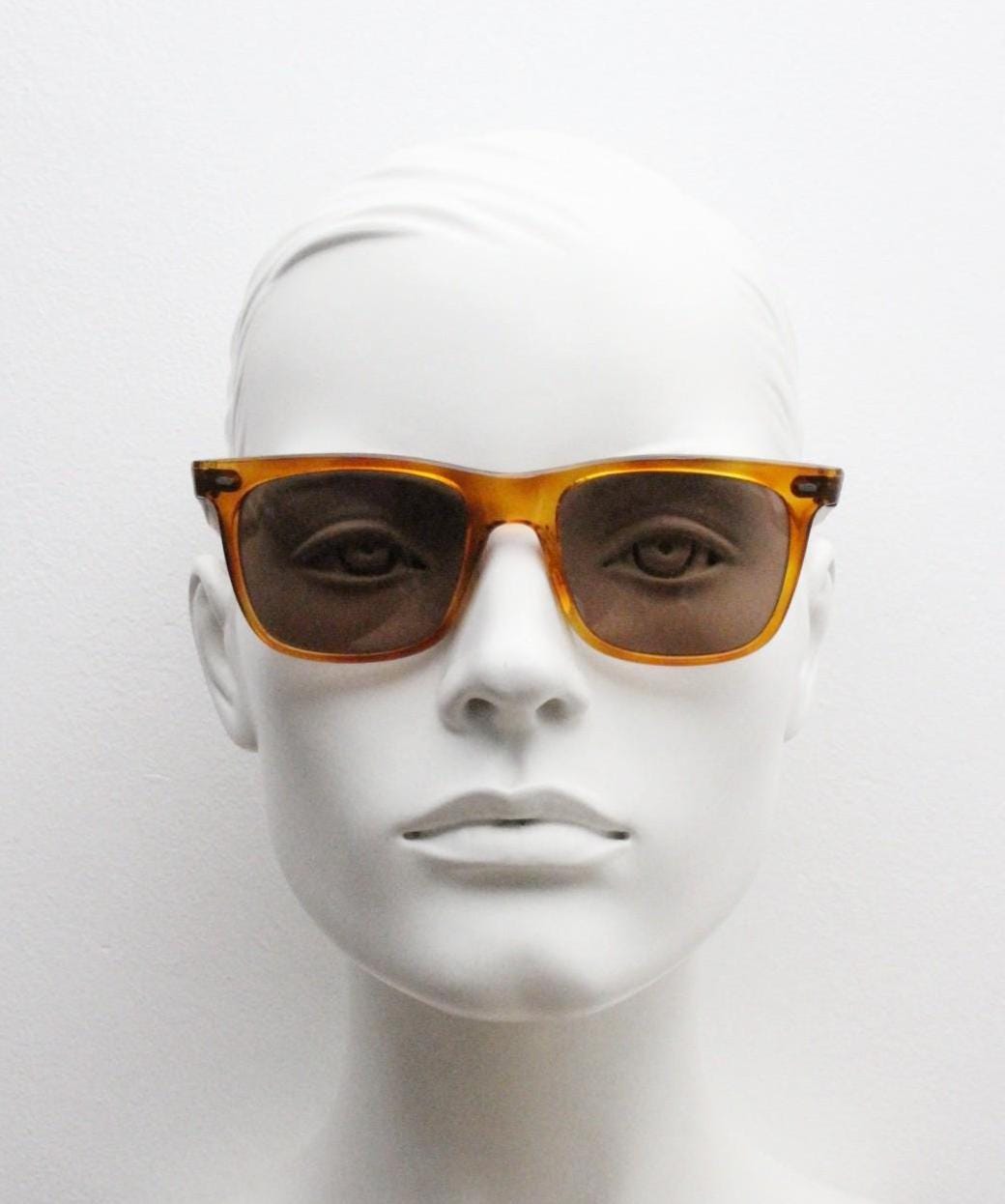 Uomo vintage 90s wayfarer design sunglasses made in Italy. All time classic format in mottled amber frame with contrasting brown lenses. NOS