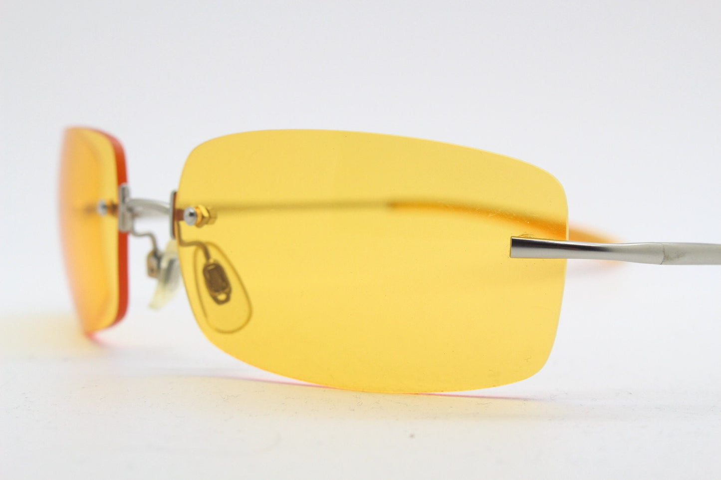 Y2K vintage frameless orange sunglasses. Rectangular wrap around lenses with satin silver bridge and arms. 2000s club kids. 00's. 90s. NOS