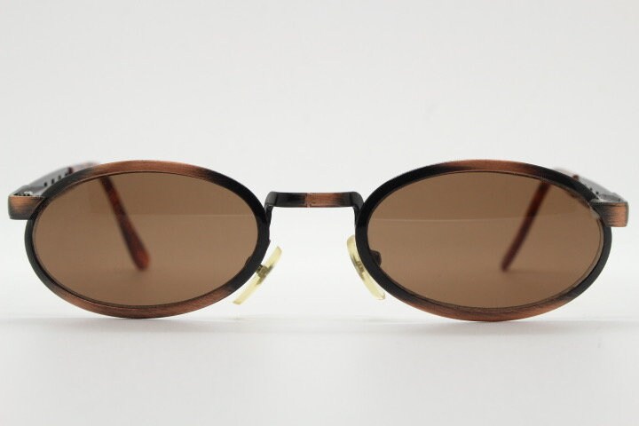 90s vintage oval sunglasses. Handsome metallic brushed copper finish with arm cut outs. Unused NOS