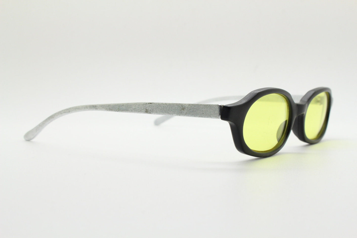 Vintage 90s oval sunglasses. Black low profile matt finish front with yellow lenses and silver chrome arms. Micro