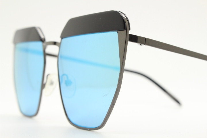 For Arts Sake angular cat eye hand made sunglasses. Black flat top 'eyebrow' design with blue mirror lenses and gunmetal grey frame
