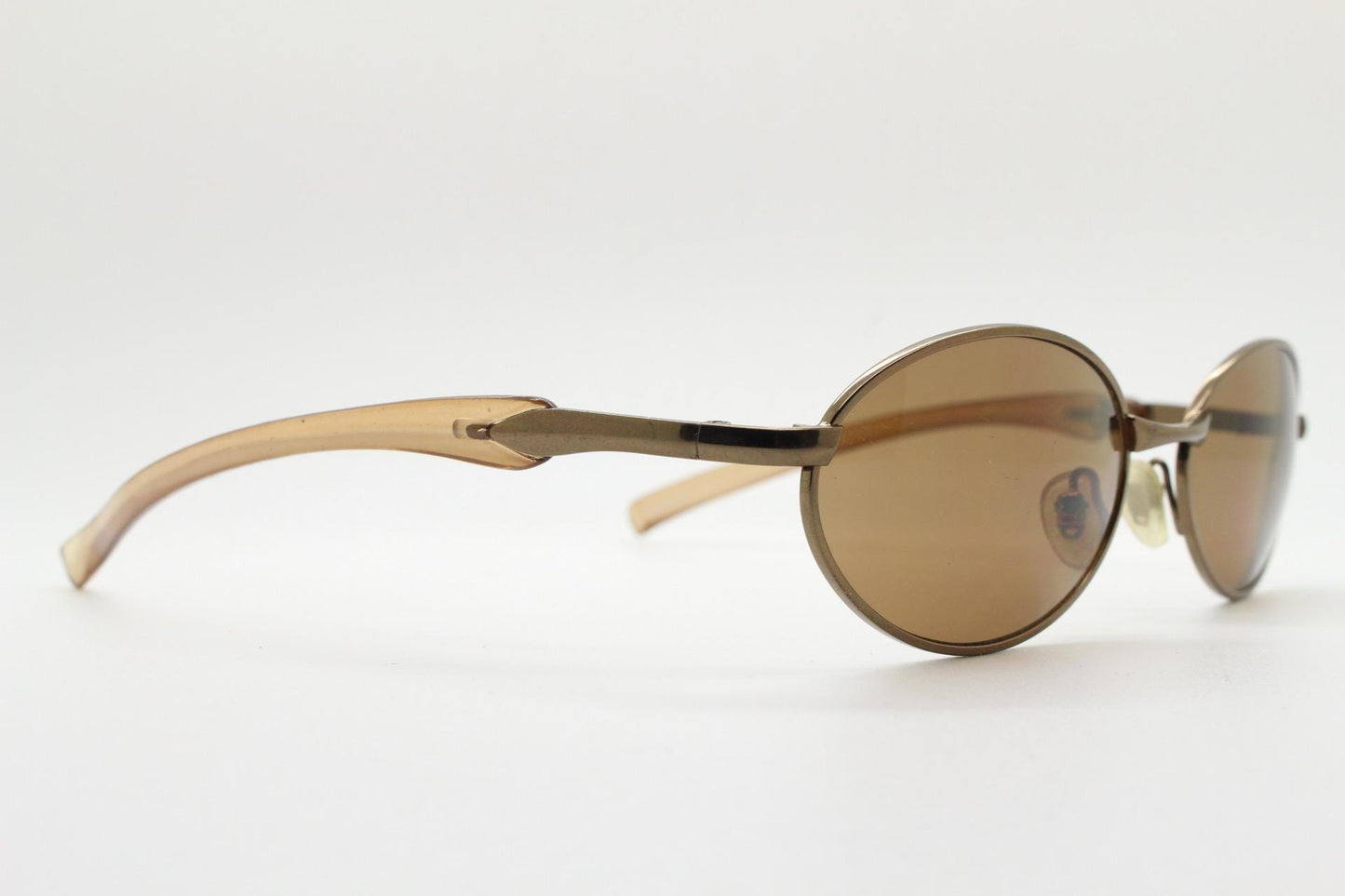 90s vintage small oval bug eye sunglasses. Minimal brown chrome finish metal frame with transparent curved arms. Y2K. Unused NOS