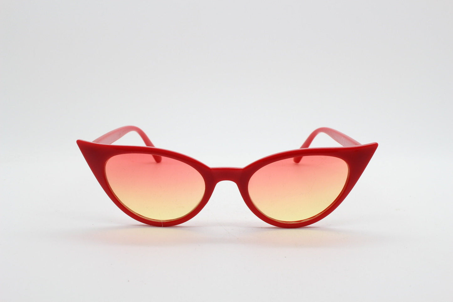 Y2K vintage pointed cat eye sunglasses. Red slender frame with graduating lenses. Womens 50s style rockabilly, pin up shades