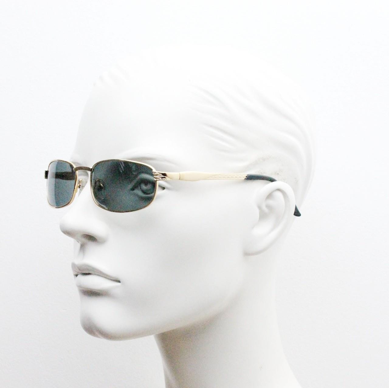 90s vintage low profile gold rectangular sunglasses. Solid metal frame in a shiny chrome finish embossed arm pattern and green lenses. NOS