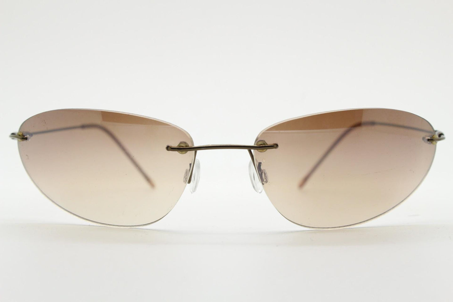 90s vintage frameless oval wraparound sunglasses. Minimal curved almond shaped lenses with brown chrome arms. 2000s NOS. Matrix cosplay