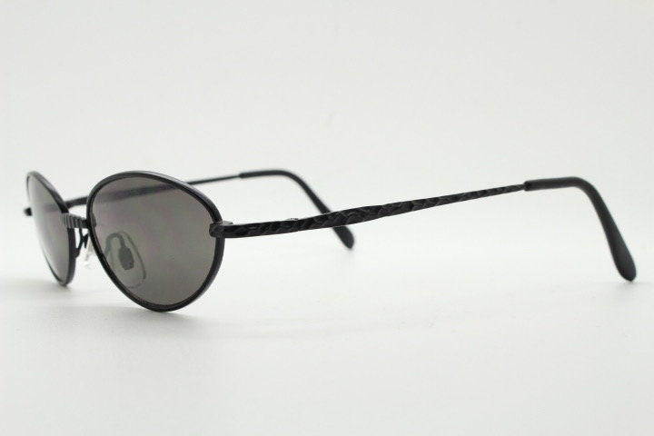90s vintage oval sunglasses. Minimal plain matt black metal frame with unusual indented arm patterns. Unused NOS