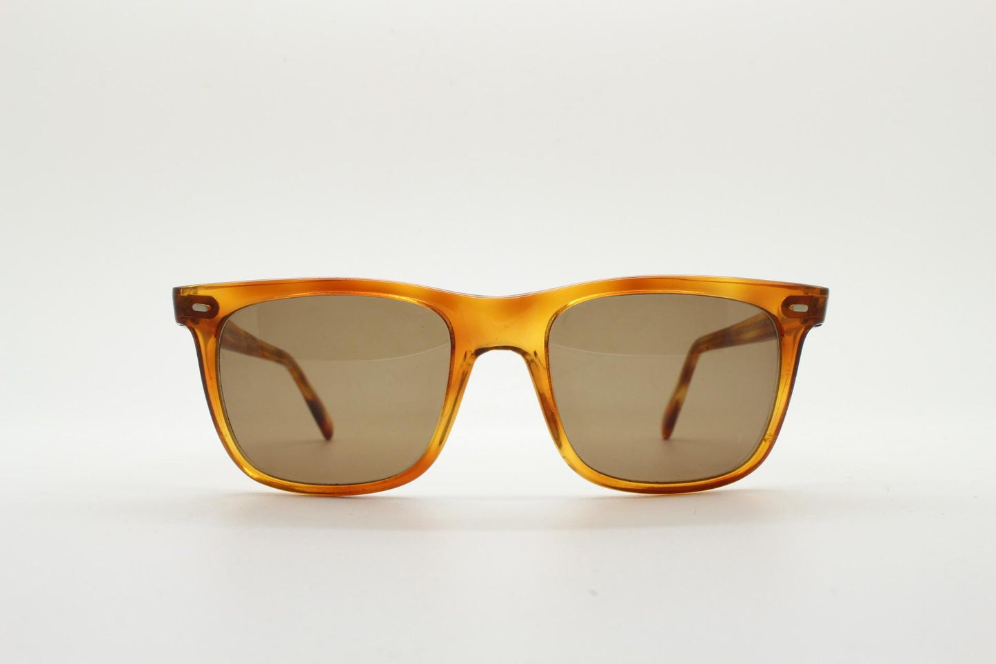 Uomo vintage 90s wayfarer design sunglasses made in Italy. All time classic format in mottled amber frame with contrasting brown lenses. NOS