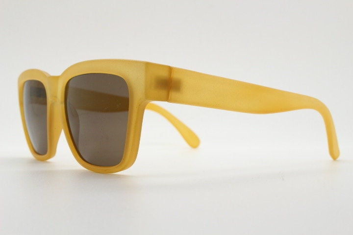 IDC lunettes modified wayfarer design sunglasses made in France. Transparent frosted yellow acetate chunky frame with contrasting lenses