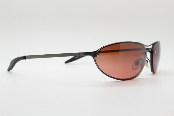 Y2K vintage oval sunglasses. Satin finish grey metal frame with amber curved almond bug eye lenses and straight arms. 2000's. NOS