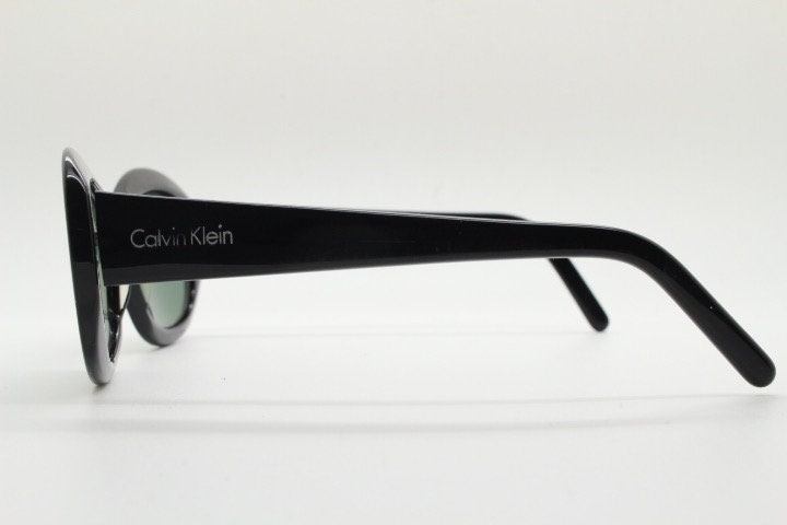Calvin Klein vintage oval cateye sunglasses made in Italy. Womens plain black gloss thickened acetate cat eye. Classical 60s design. Y2K
