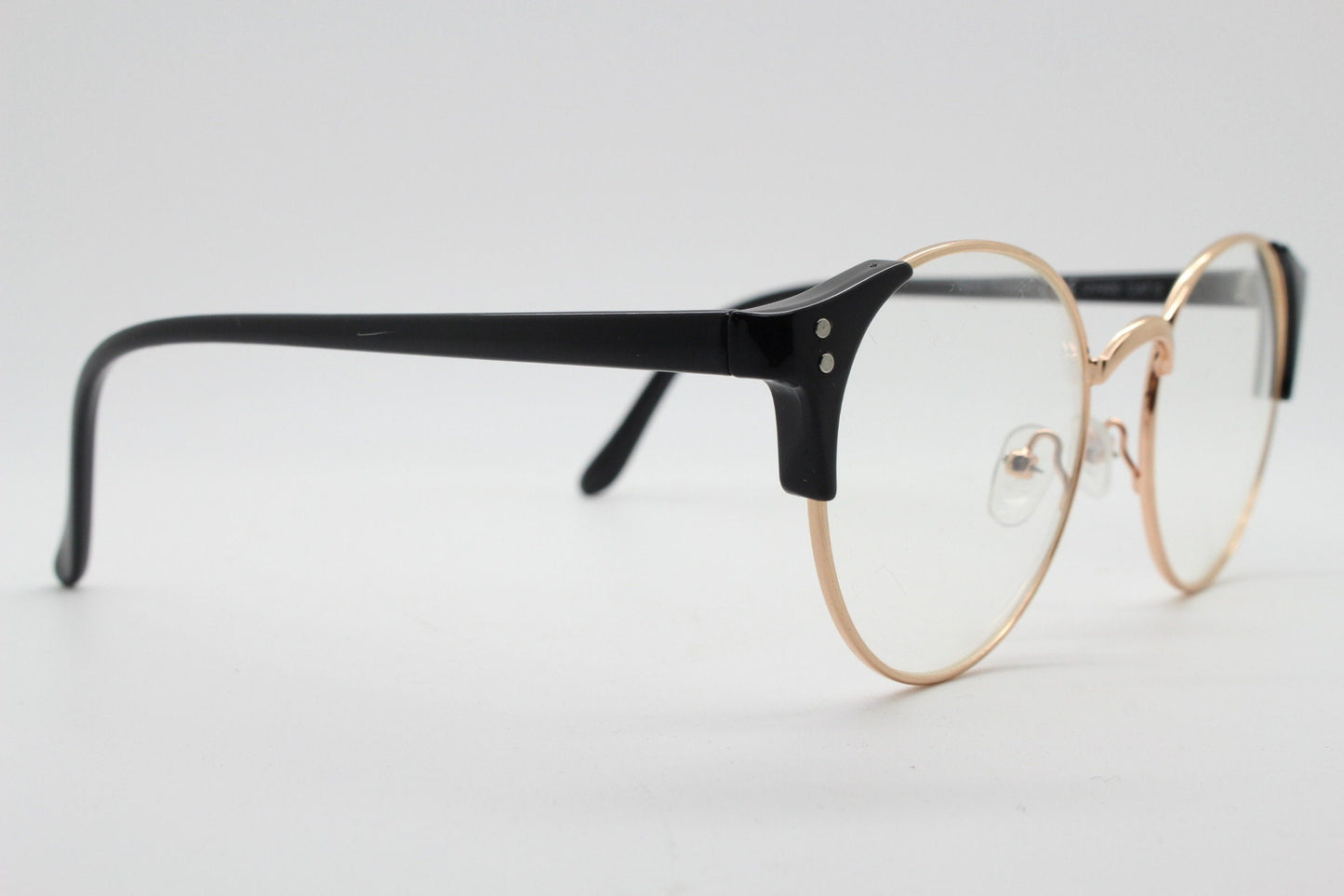 90s vintage modified cat eye glasses. Black arms with a round gold face. 40s, 50s style clear lens eyeglasses. Cateye