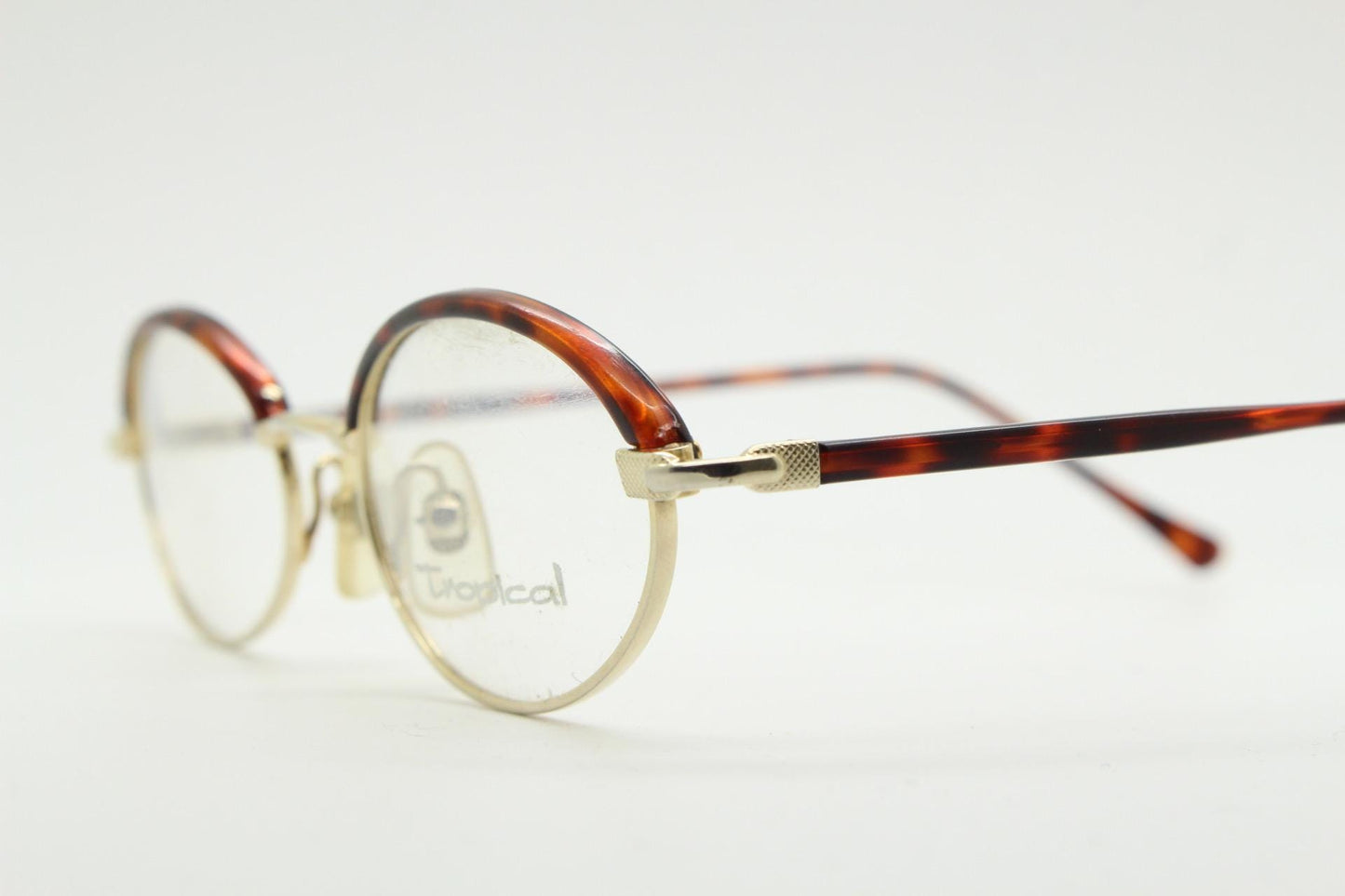 90s vintage small oval eye glasses by Tropical. Minimal gold optical frames with tortoise arms and brows. Prescription RX spectacles. NOS