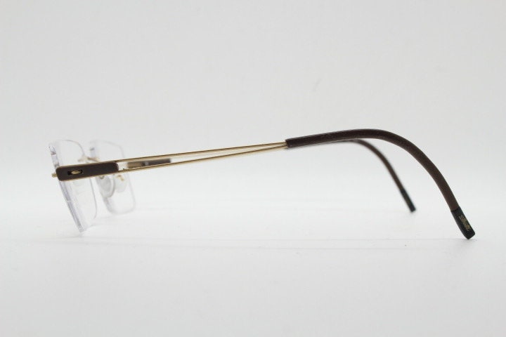 Silhouette rectangular frameless eye glasses model 7677 made in Austria. Minimal lightweight optical frame with golden trim. Prescription RX