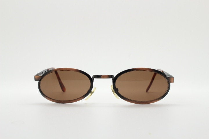 90s vintage oval sunglasses. Handsome metallic brushed copper finish with arm cut outs. Unused NOS