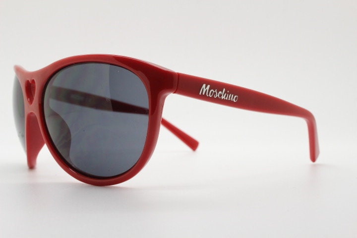 Moschino oversized Y2K vintage sunglasses. Characteristic crimson red acetate frame with cut out heart bridge. 2000s