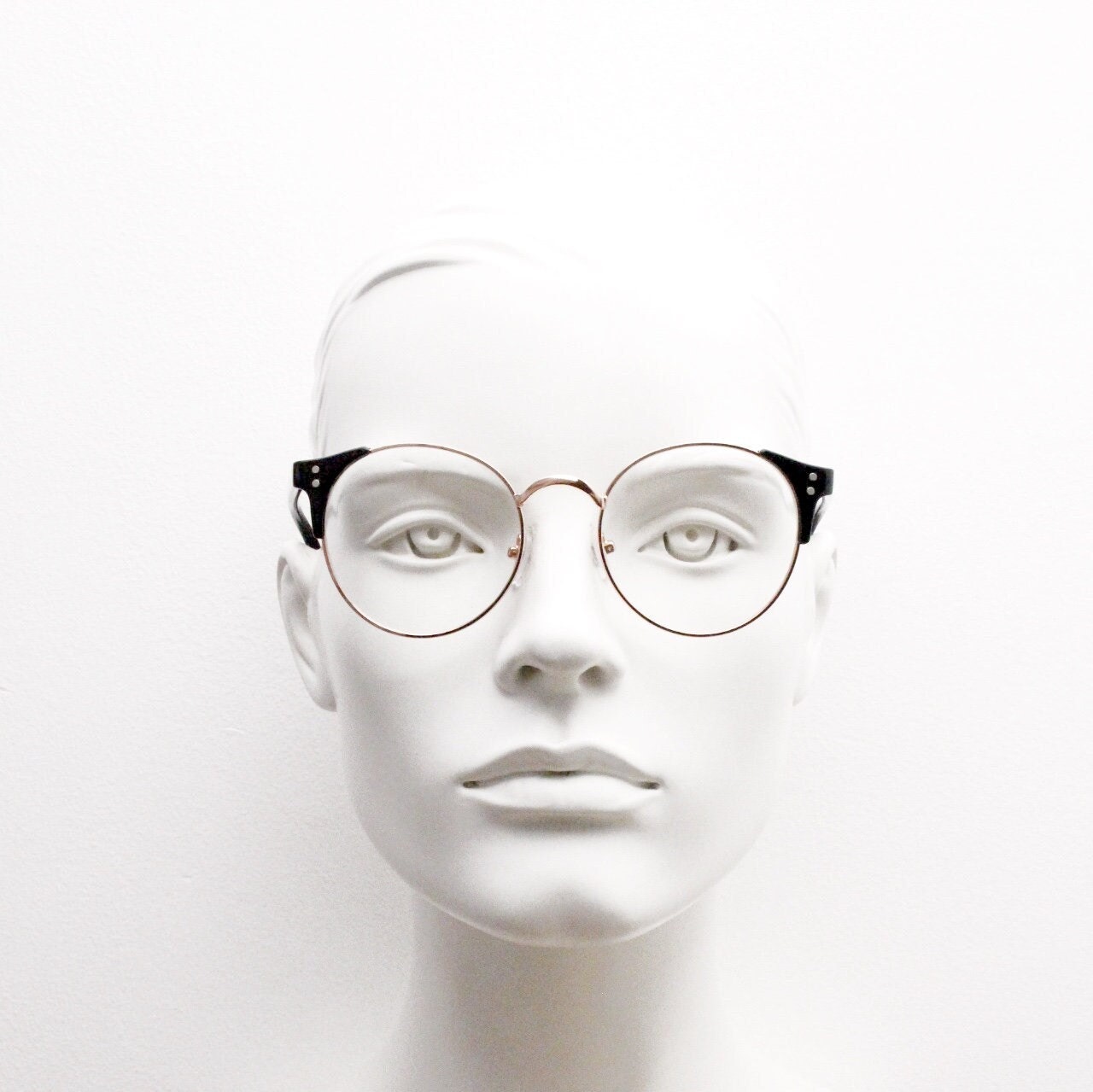 90s vintage modified cat eye glasses. Black arms with a round gold face. 40s, 50s style clear lens eyeglasses. Cateye