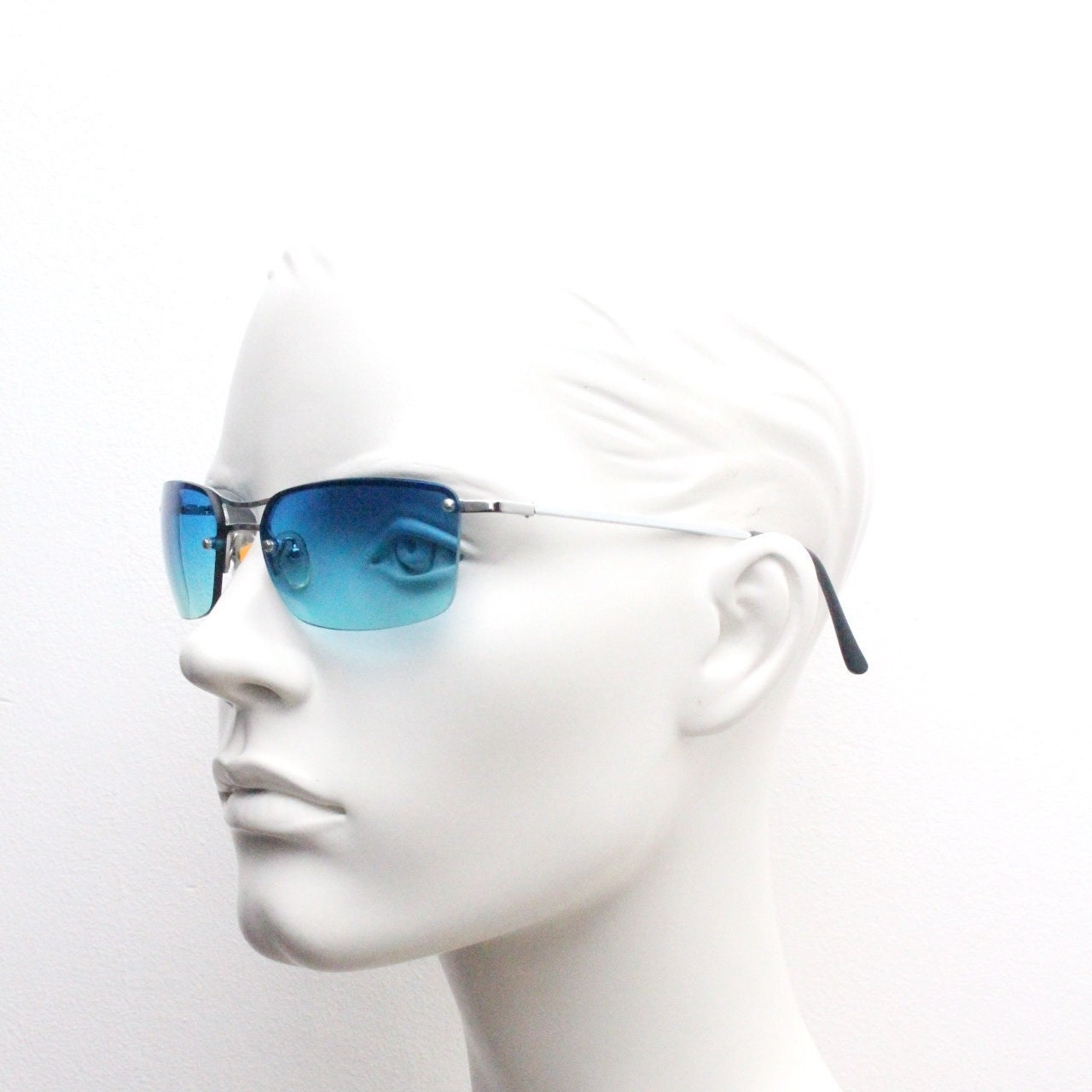 Y2K vintage visor sunglasses. Half frame wraparound shield design with light tone graduating turquoise to aquamarine lens. 2000's. 90s. NOS