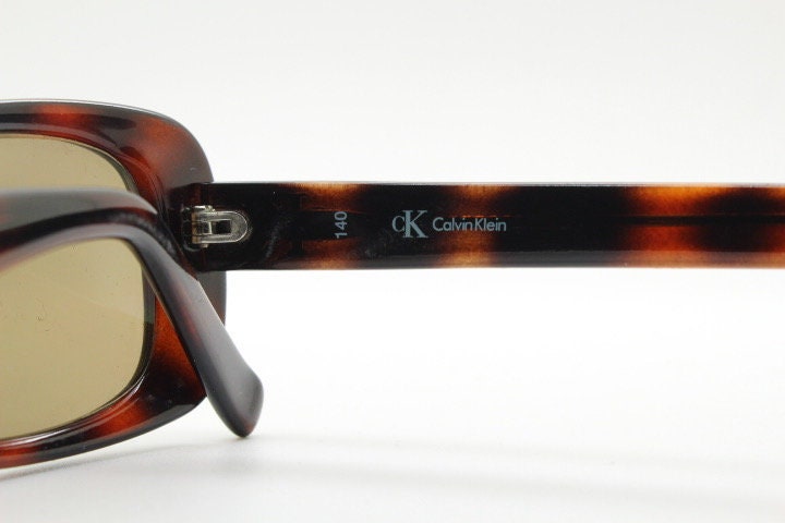 Calvin Klein 90s vintage thick framed rectangular sunglasses. Womens dark tortoise gloss low profile design.