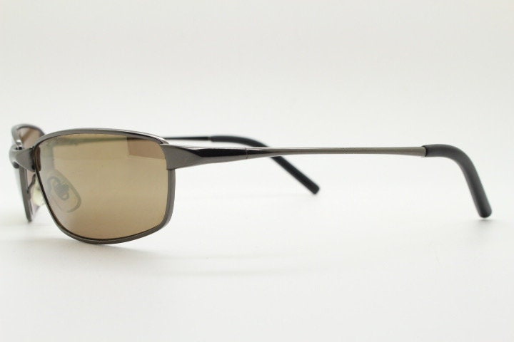 90s vintage curved rectangular sunglasses. Solid metal low profile frame in brown chrome with slightly mirrored lenses. 2000's. Y2K NOS