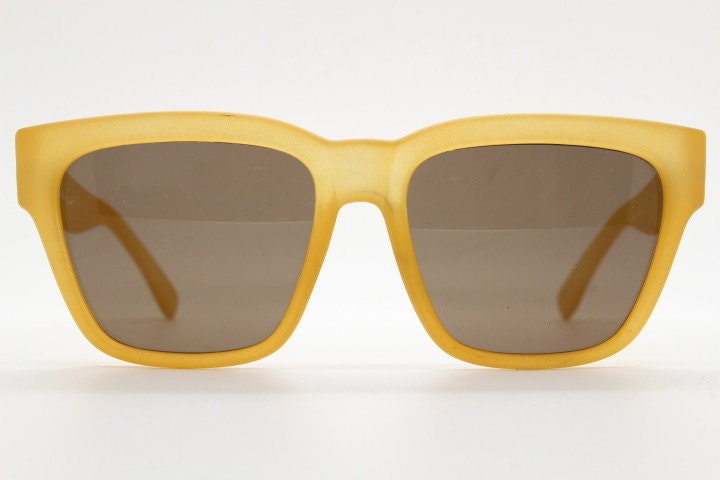 IDC lunettes modified wayfarer design sunglasses made in France. Transparent frosted yellow acetate chunky frame with contrasting lenses