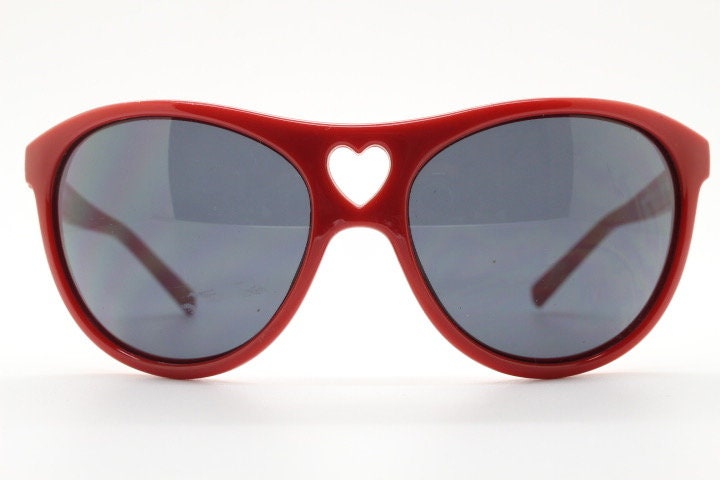 Moschino oversized Y2K vintage sunglasses. Characteristic crimson red acetate frame with cut out heart bridge. 2000s