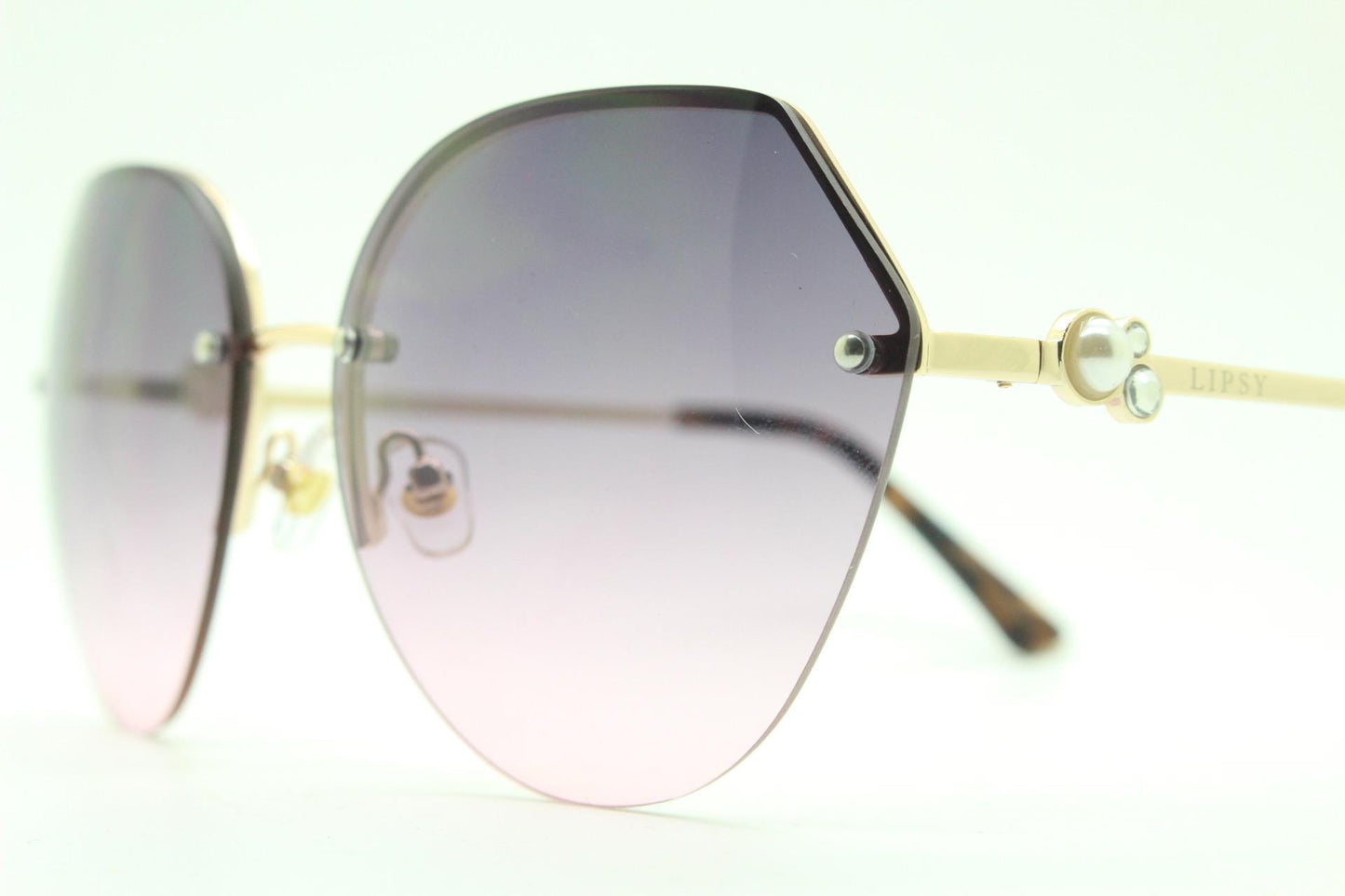 Large rimless sunglasses with dynamic angular grey to pink graduating lenses. Women's 80s vintage style half frame with gold arms