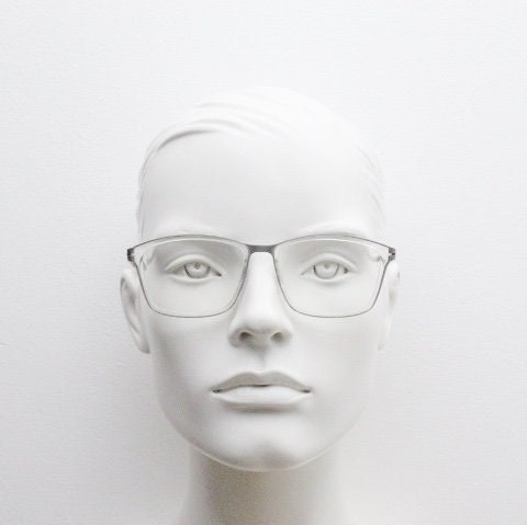 Modo rectangular eye glasses made in Japan. Matt grey titanium optical frame encasing transparent crystal acetate front. Prescription RX