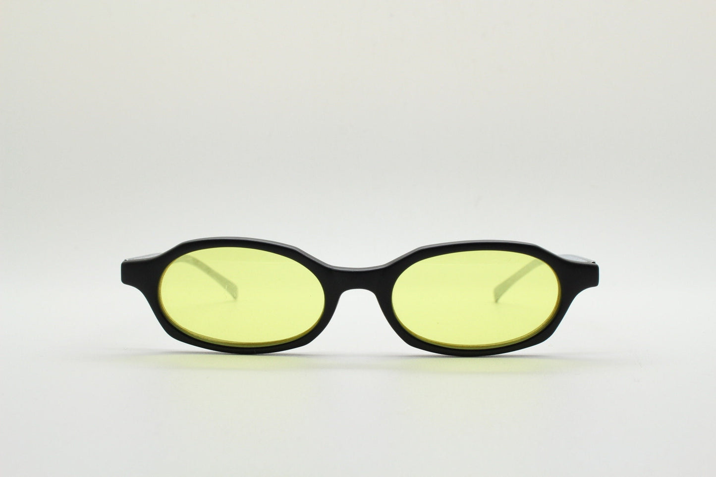 Vintage 90s oval sunglasses. Black low profile matt finish front with yellow lenses and silver chrome arms. Micro