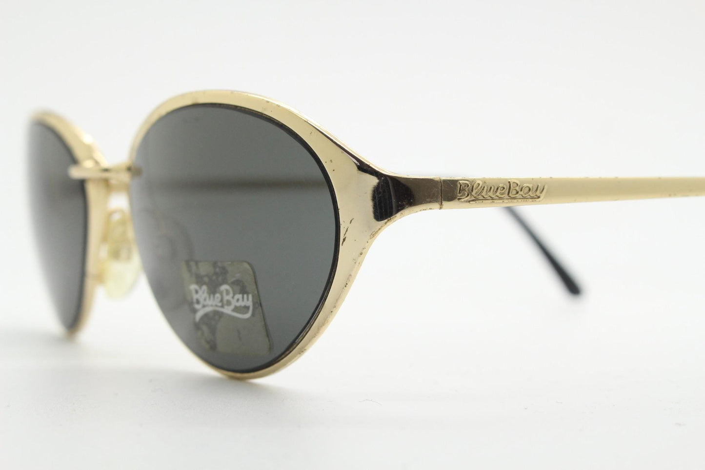Blue Bay 90s vintage oval cat eye sunglasses made in Italy by Safilo. Dynamic gold chrome finish with contrasting dark lenses. NOS with tag