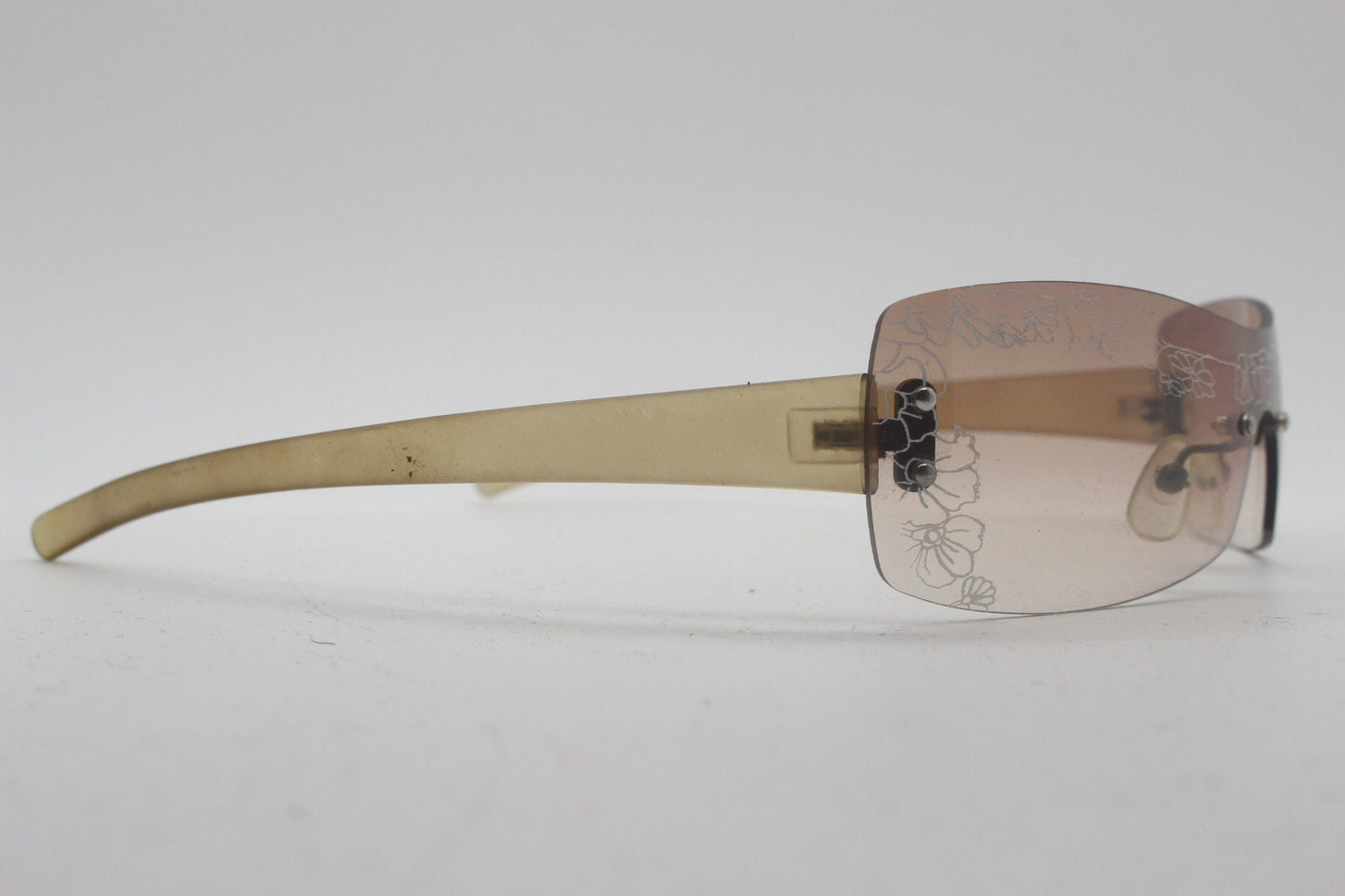 Y2K vintage visor sunglasses. Frameless 2000's wraparound mini mask shield design with light tone mono lens and flower print. 00s NOS
