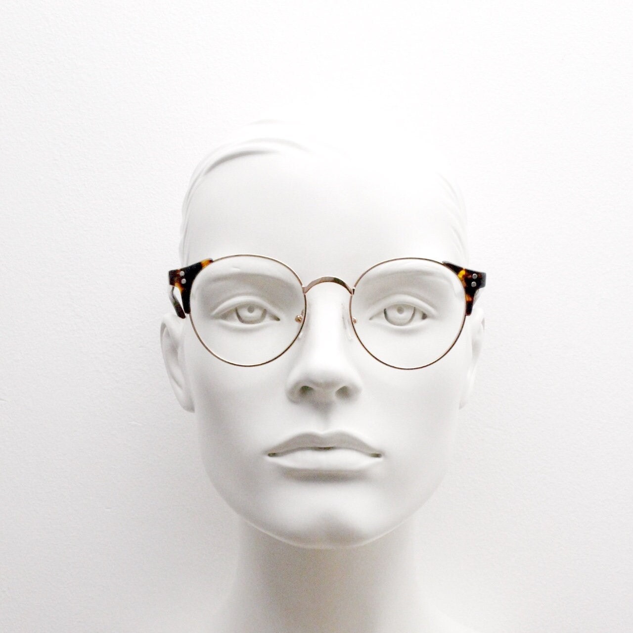 90s vintage modified cat eye glasses. Tortoise arms with a round gold face. 40s, 50s style clear lens eyeglasses. Cateye