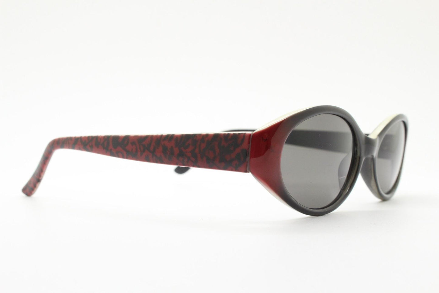 Vintage 90s oval sunglasses with very unique abstract arm pattern in black and red on layered acetate. Authentic original design. NOS
