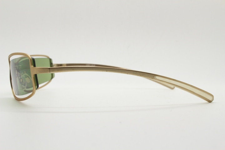 Y2K vintage wraparound sunglasses. Low profile satin finish golden slender frame with green lenses and gap feature. 2000's. 90s. NOS