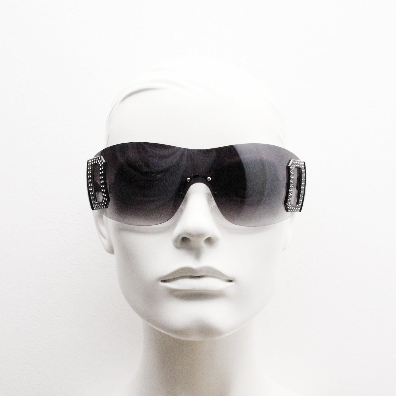 Y2K vintage visor sunglasses. 2000's black wraparound mono lens shield design with big diamante effect crest. 00s uber fashion mini mask NOS