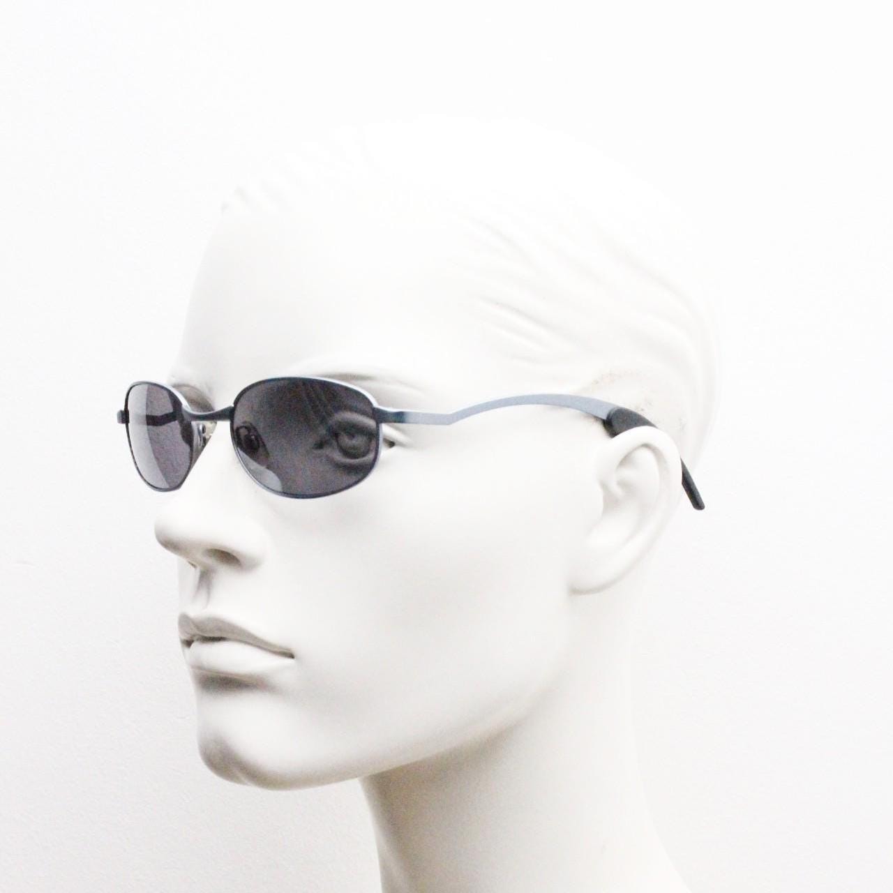 90s vintage oval small bug eye sunglasses. Curved blue satin finish solid metal frame with stylised arched arms and rubber ends. Unused NOS