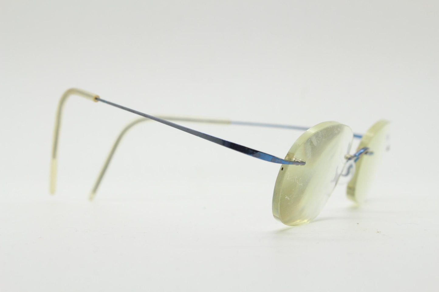 Frameless vintage oval eye glasses. Extremely minimal lightweight blue titanium optical frame with springy hingeless arms. 2000s