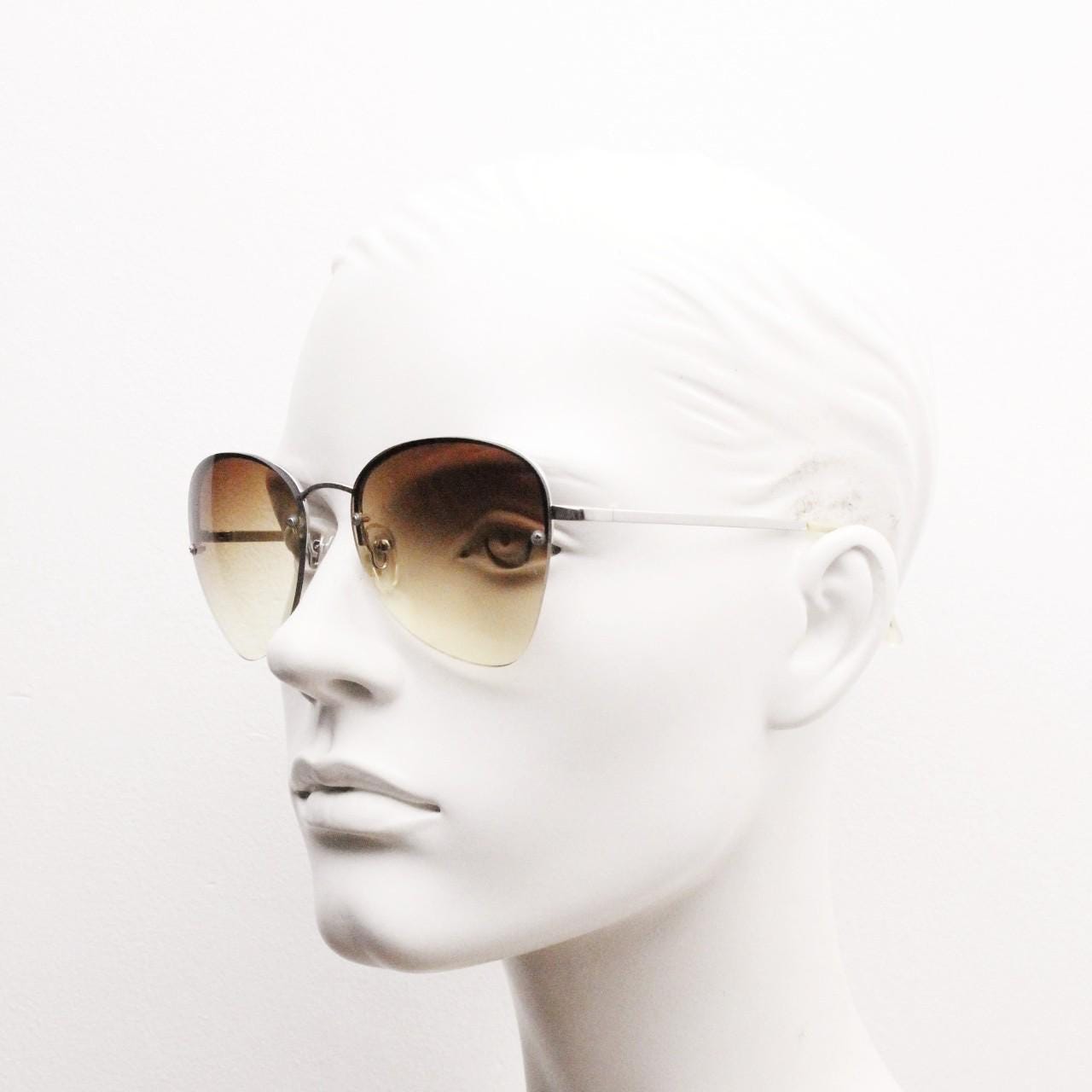 90s vintage modified teardrop aviator sunglasses. Minimal metal silver chrome half frame with compelling lenses. Teardrop aviators. NOS
