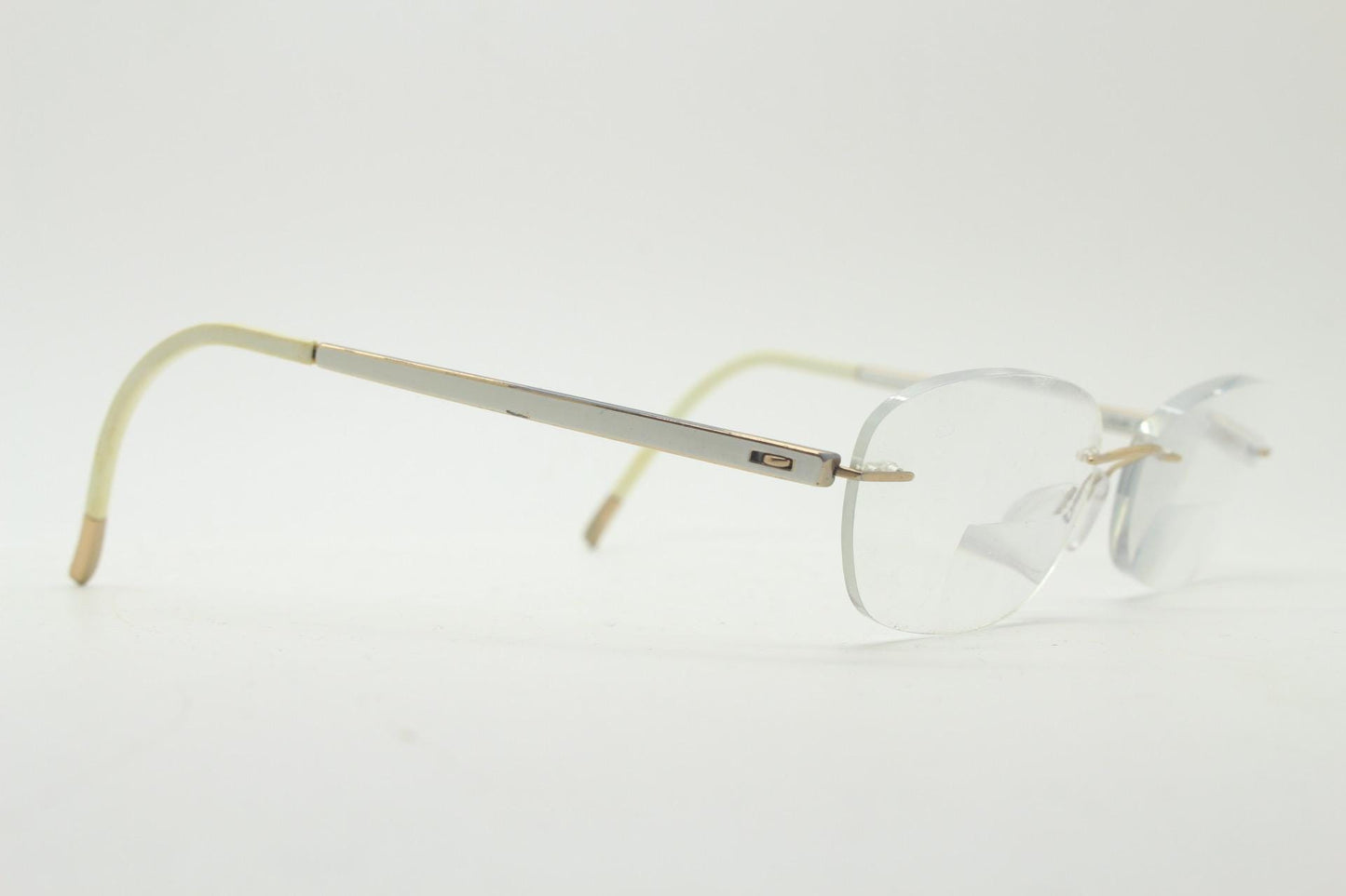Silhouette rectangular frameless eye glasses made in Austria. Minimal lightweight gold with white enamel frame. 90s vintage. Prescription RX