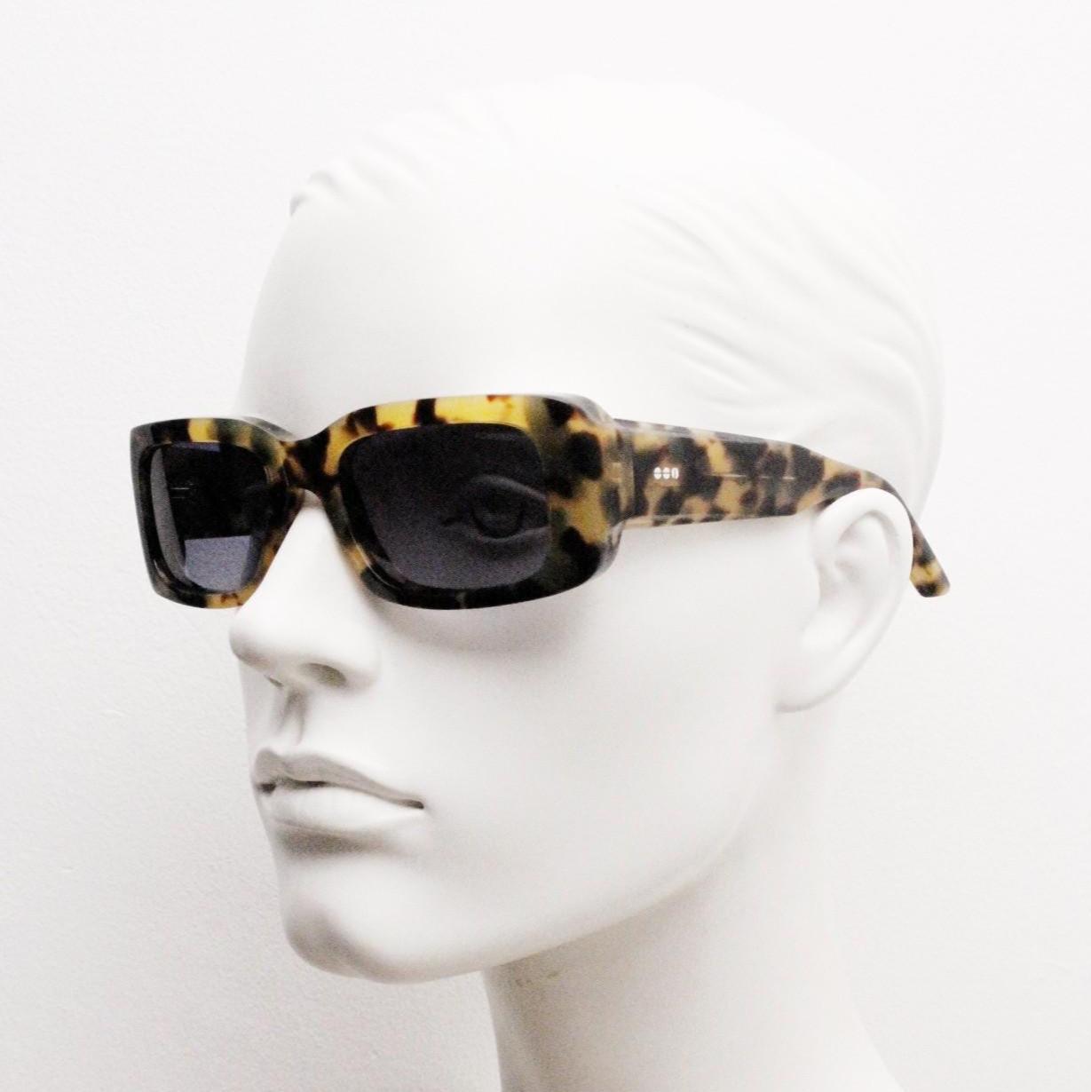 Komono chunky rectangular sunglasses model The Wes. Thick framed honey tortoise eco acetate with curved back 'goggle' sides and tall arms.