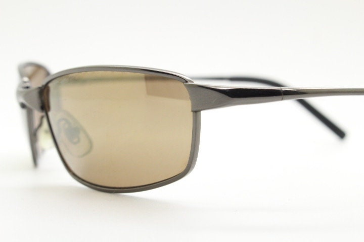 90s vintage curved rectangular sunglasses. Solid metal low profile frame in brown chrome with slightly mirrored lenses. 2000's. Y2K NOS