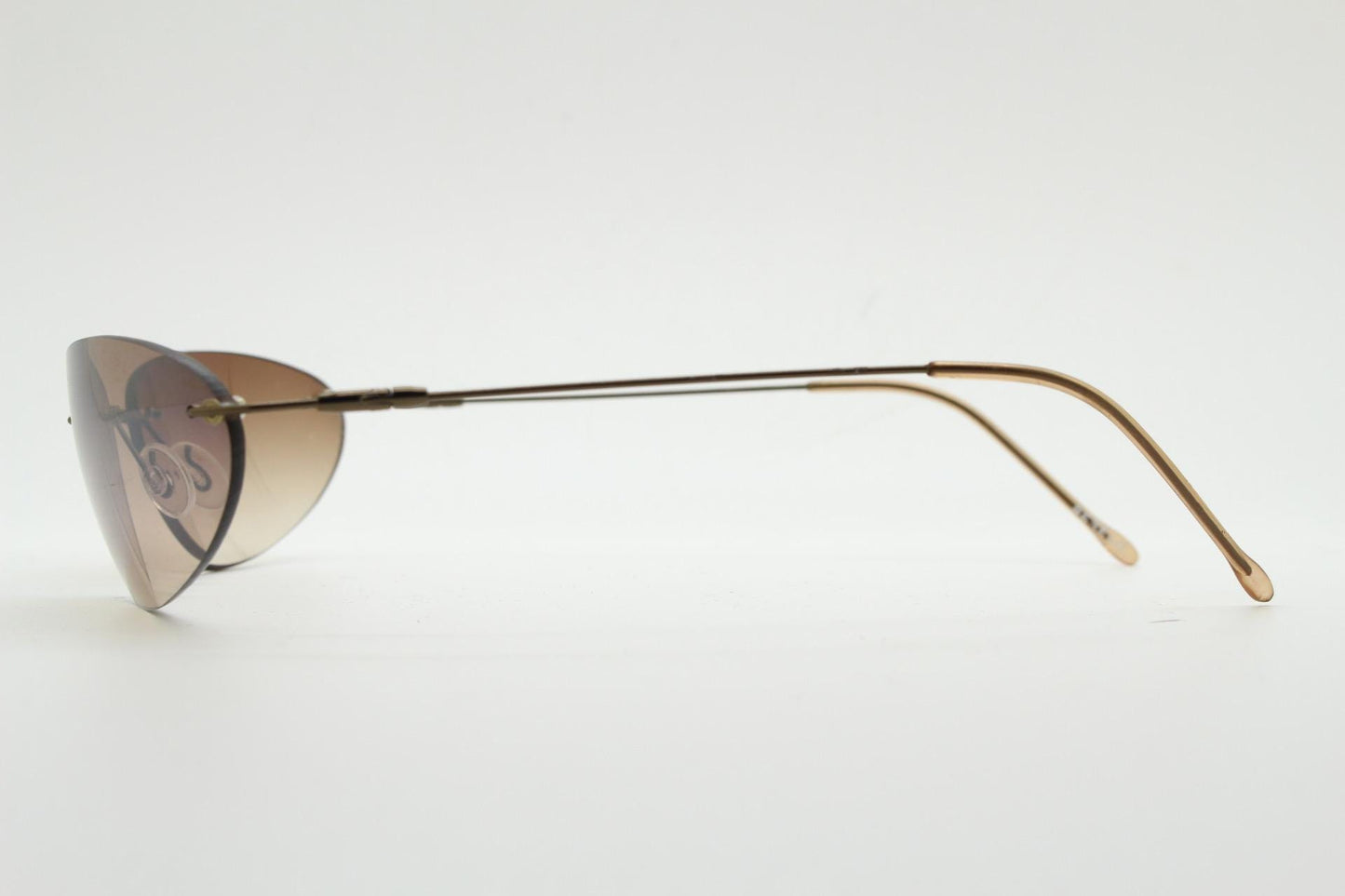 90s vintage frameless oval wraparound sunglasses. Minimal curved almond shaped lenses with brown chrome arms. 2000s NOS. Matrix cosplay