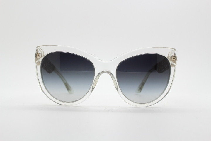 Dolce and Gabbana oversized cateye sunglasses model 4211. Womens transparent cat eye with cut-out florid metal arms and smoky lenses. NOS