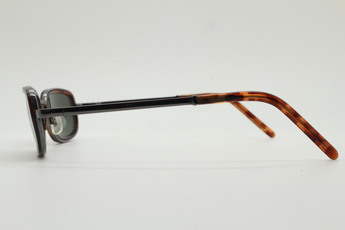 90s vintage rectangular sunglasses. Grey chrome metal frame with protruding tortoise insets, matching ear bends and green lenses