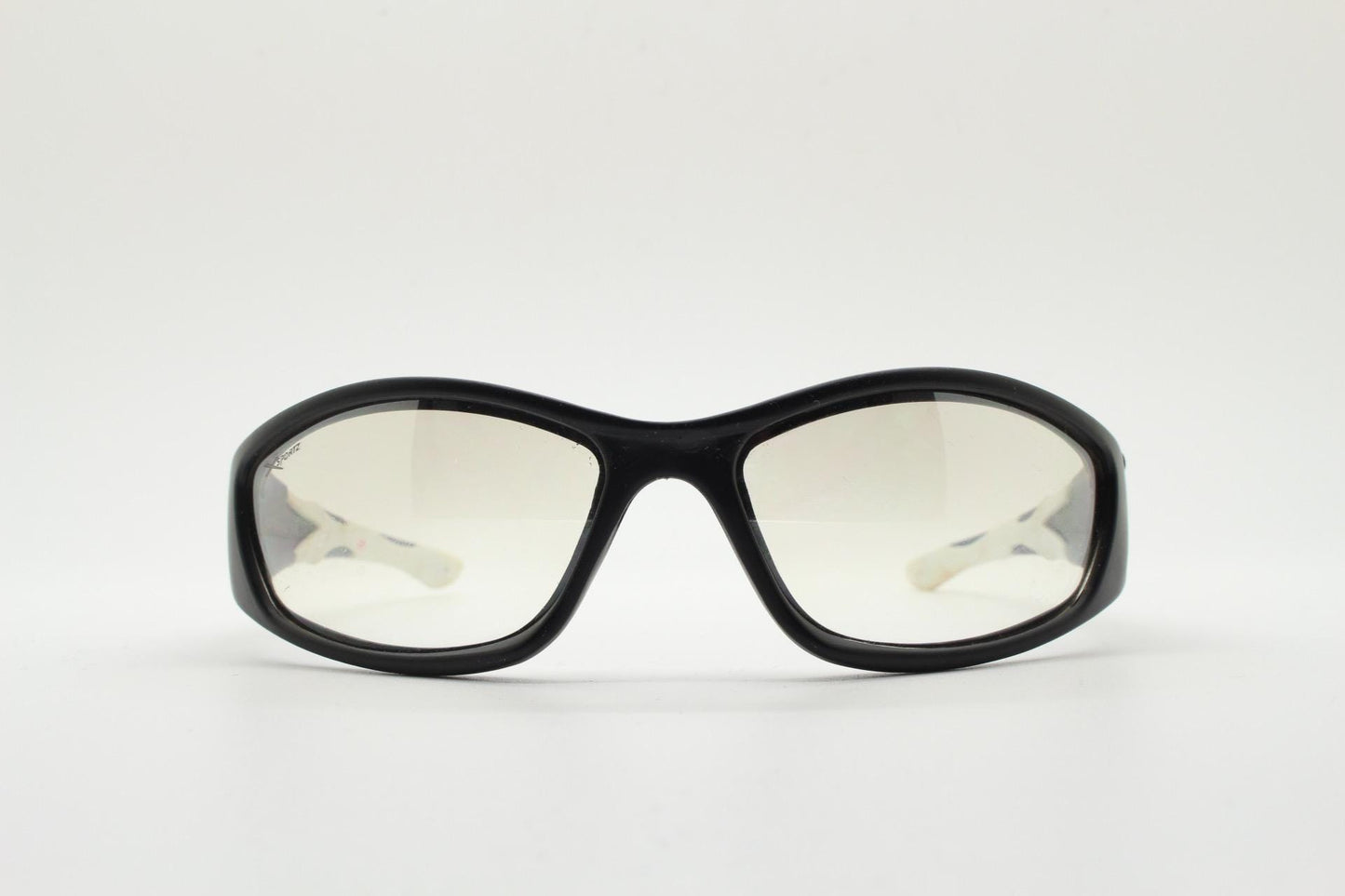 90s vintage sports sunglasses. Black matt aerodynamic wraparound with straight white rubber arms and light tone lenses. Y2K rave shield